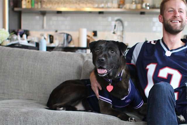 man on couch with black dog