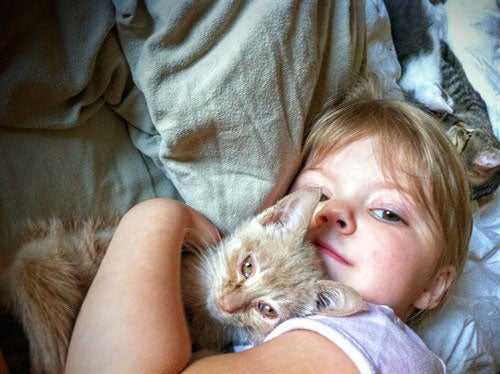 Kid hugging cat
